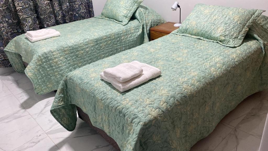2 camas con toallas en una habitación en WHITE HOUSE en San Salvador de Jujuy
