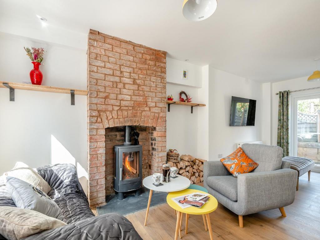 a living room with a couch and a fireplace at Garway Cottage in Ross on Wye