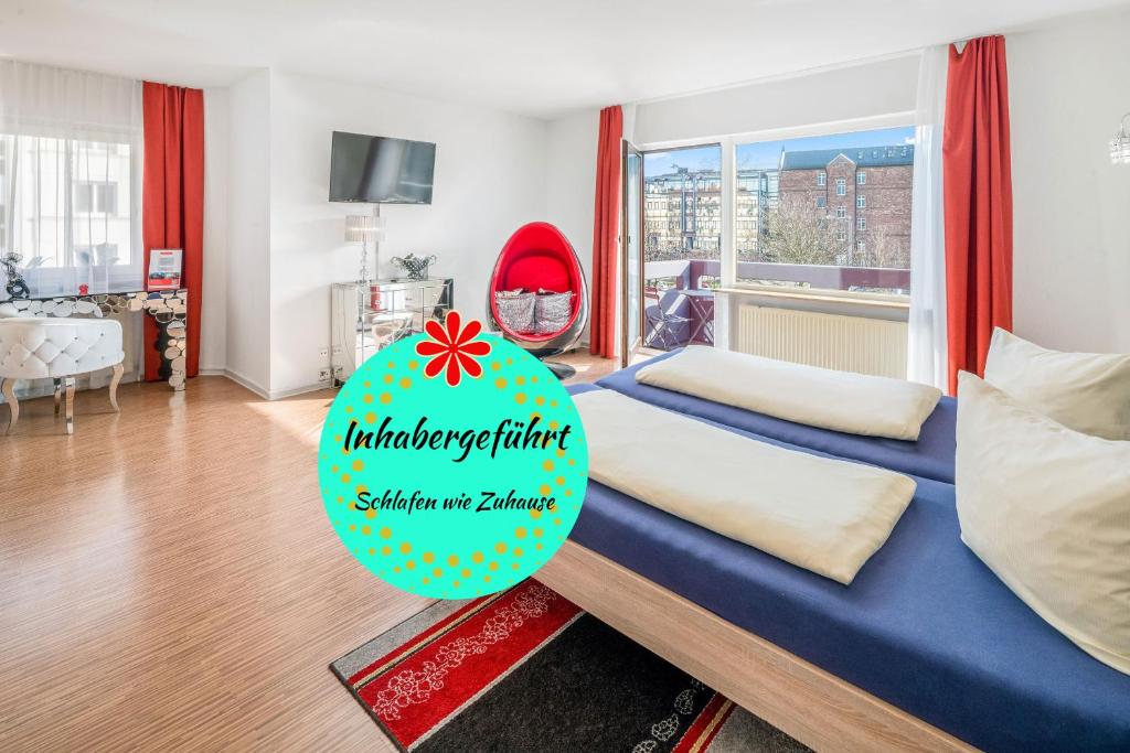 Una habitación con una cama azul con un signo de cumpleaños feliz. en Hotel Am Gottesauer Schloss, en Karlsruhe