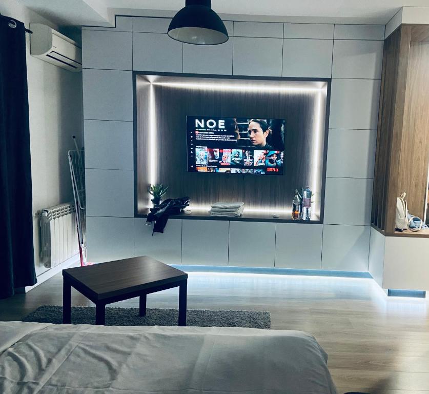 a living room with a tv on a wall at Iulius Mall Loft in Iaşi