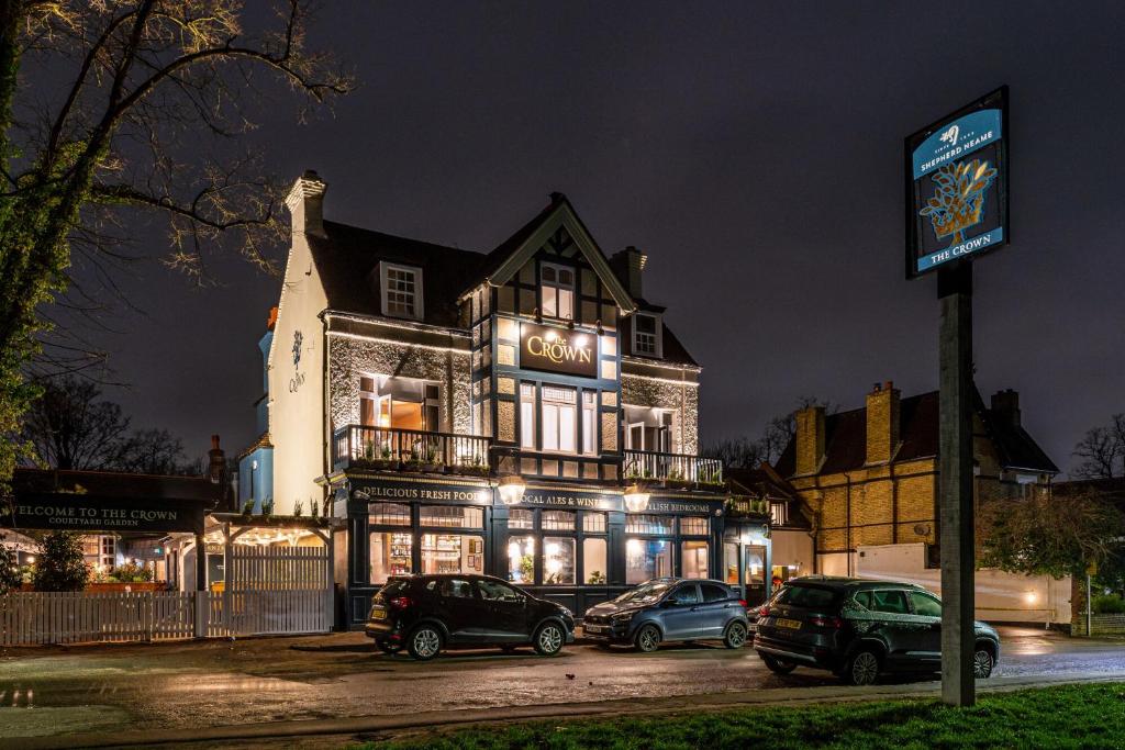 um grande edifício com carros estacionados em frente em The Crown Inn em Bromley