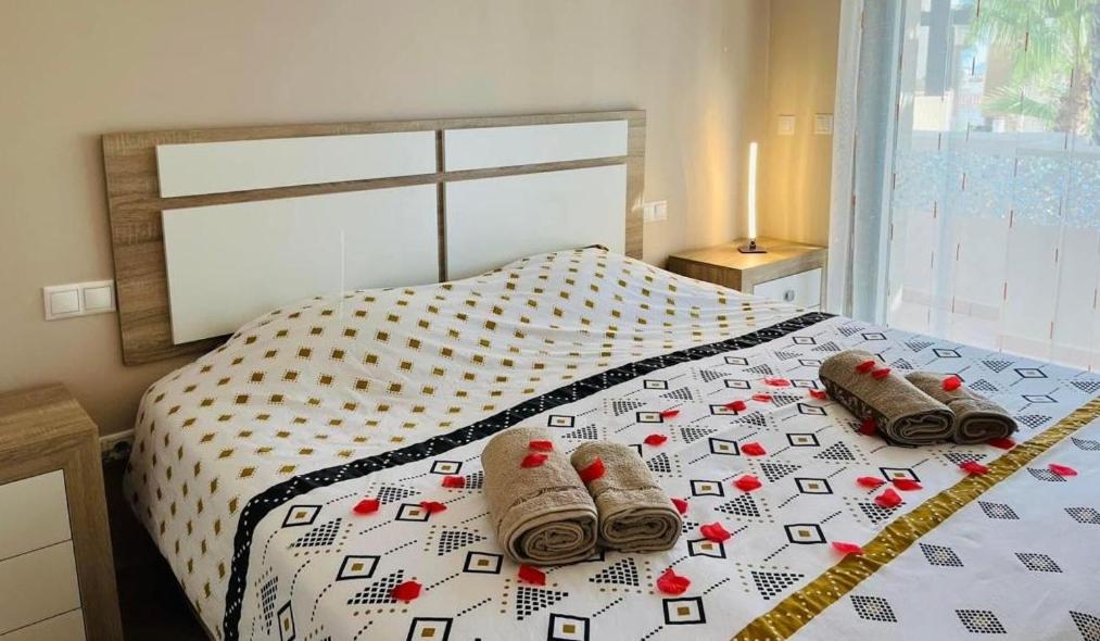 een slaapkamer met een bed met sokken erop bij Penthouse Casa Baja las Palmeras - Roda Golf in San Javier
