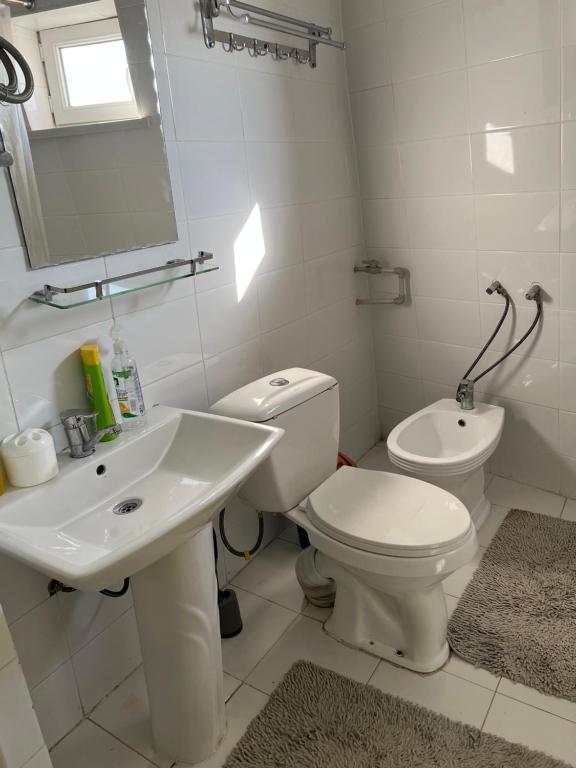 a white bathroom with a toilet and a sink at Anisa- Hostel in Dushanbe