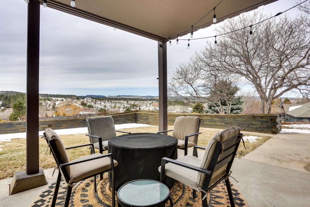 a patio with a table and chairs and a large window at Rapid City Apartment with Mountain Views! in Rapid City
