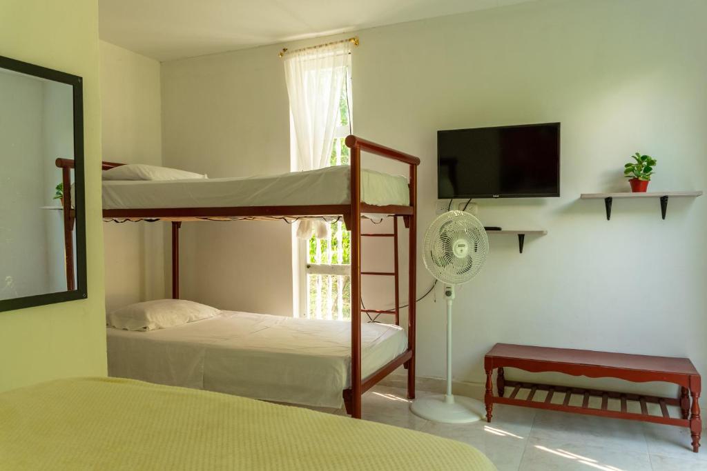 a bedroom with two bunk beds and a flat screen tv at Casa El Limonar Garzón Hospedaje Campestre in Garzón
