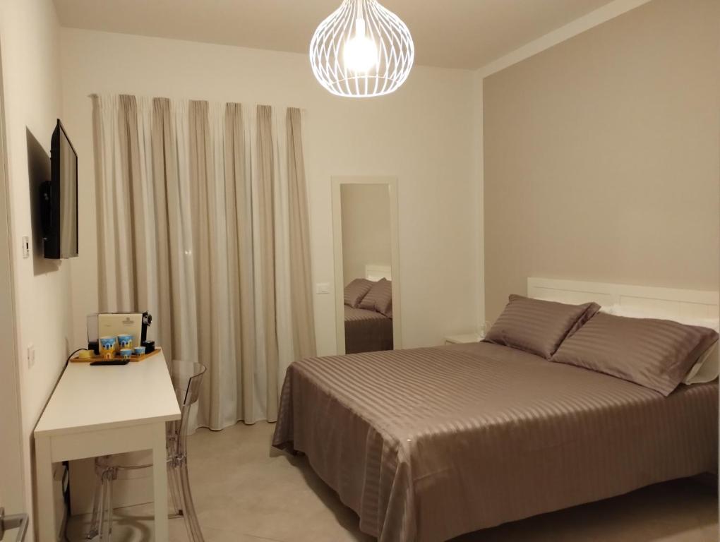 1 dormitorio con cama, mesa blanca y lámpara de araña en LA LAMPARA, en Carrara