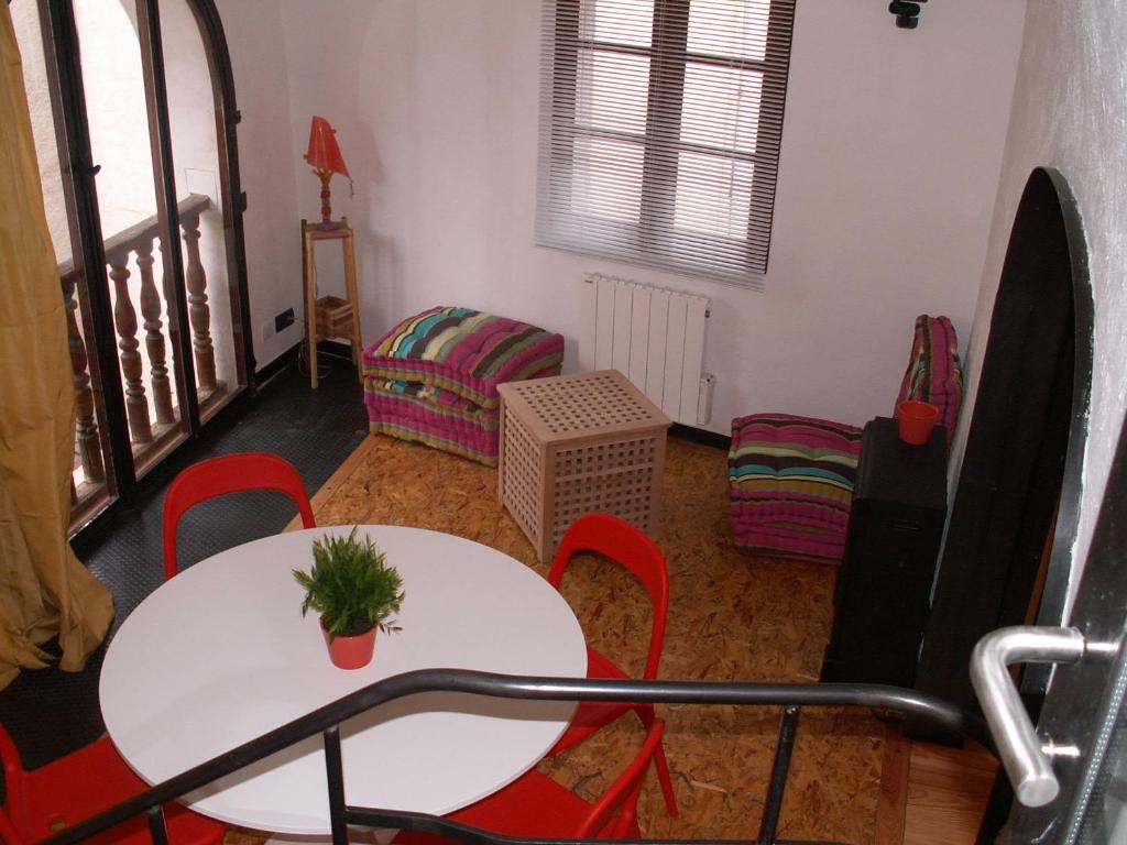 a living room with a white table and red chairs at Galetas 50 in Saint-Étienne-de-Tinée