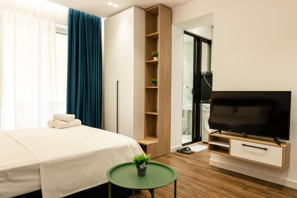 a bedroom with a bed and a flat screen tv at Tranquil Studio in Tirana in Tirana