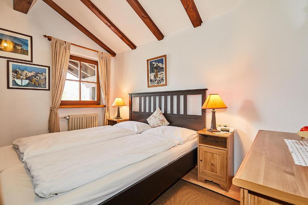 a bedroom with a bed and a desk with two lamps at Chalet Dr. Datz in Reit im Winkl