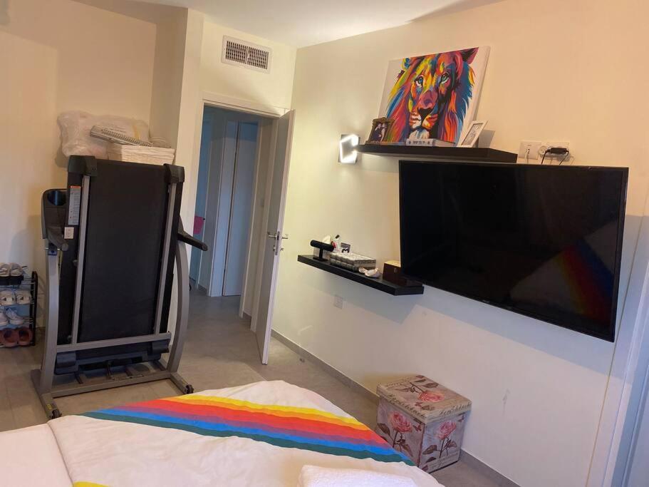 een woonkamer met een flatscreen-tv aan de muur bij Dudger home in Yehud