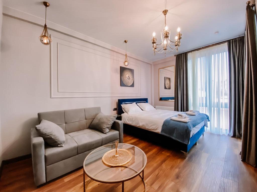 a bedroom with a bed and a couch and a table at Trinity Hotel in Tbilisi City