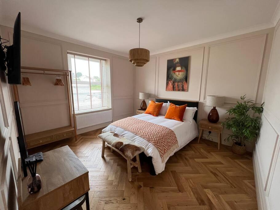 1 dormitorio con 1 cama con almohadas de color naranja en Cottage in Pembroke, Close to beaches, en Pembrokeshire