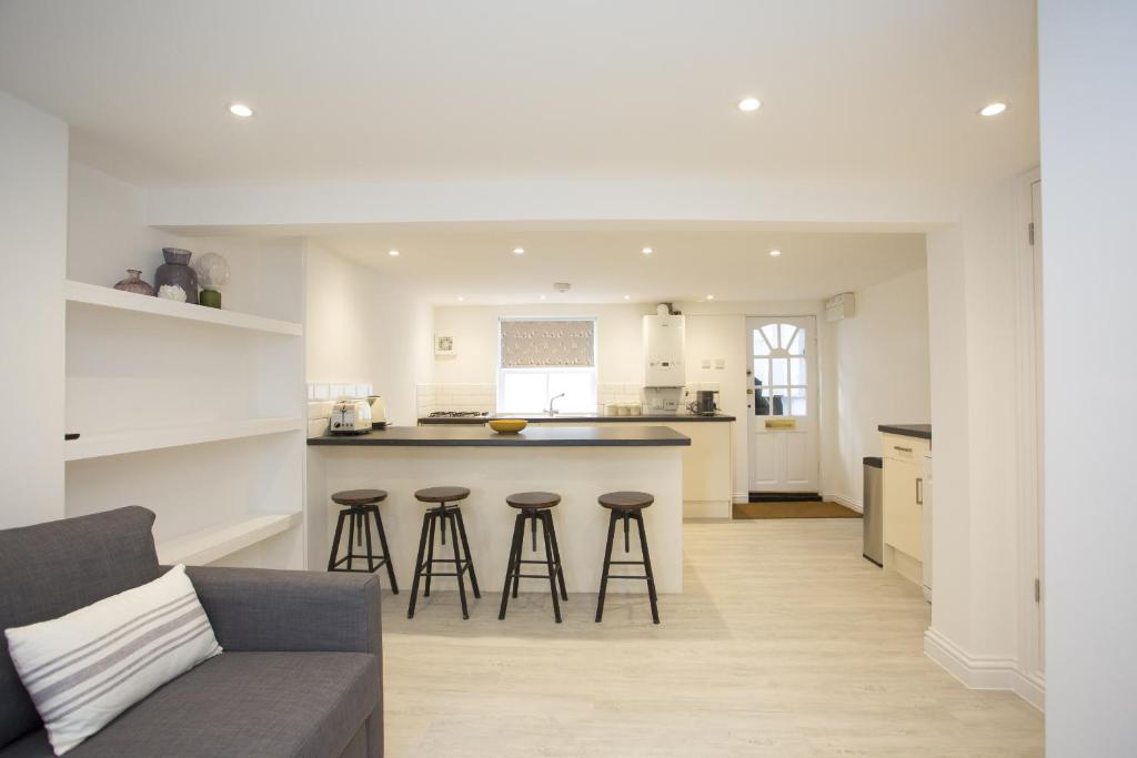 a kitchen and living room with a counter and stools at Garden View in Worthing