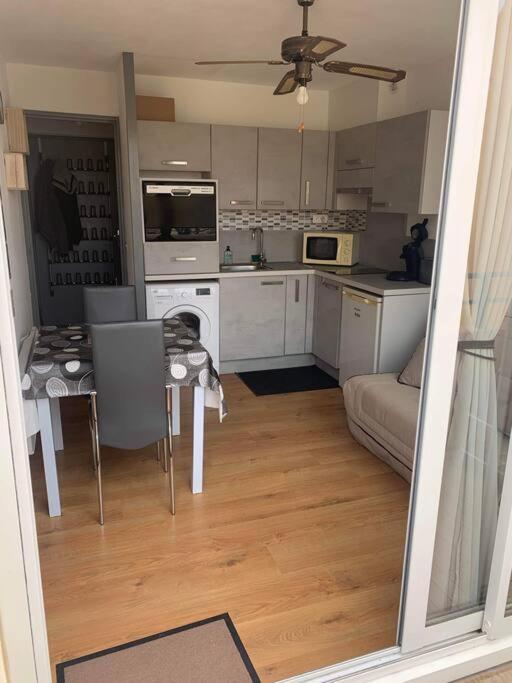 cocina y sala de estar con mesa y sofá en Appart 5 pers port de Gruissan, en Gruissan