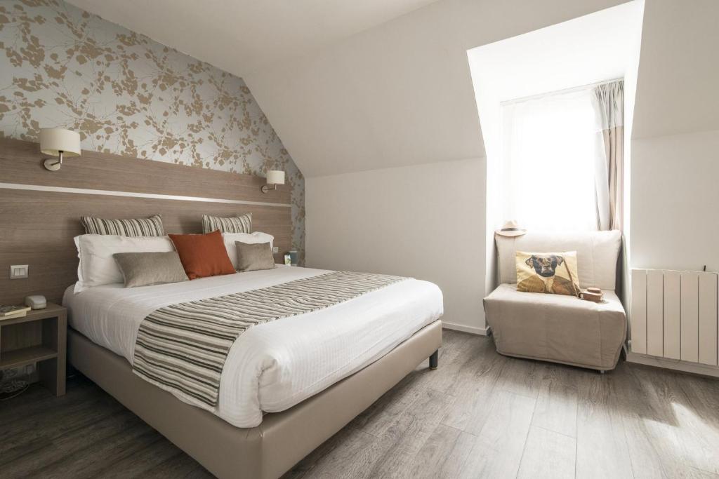1 dormitorio con 1 cama grande y 1 silla en Logis Beaujoire Hôtel, en Nantes