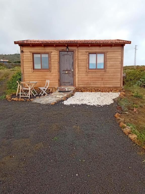 a log cabin with a door and a chair outside at Las casitas de Pao in El Pinar del Hierro