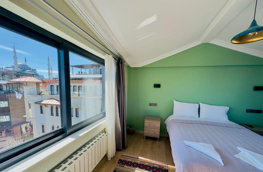 a bedroom with a bed and a large window at Terrace Guesthouse in Istanbul