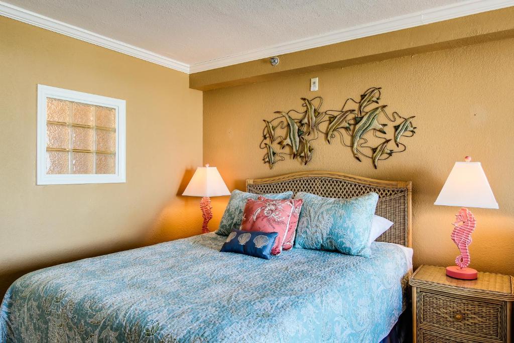 デイトナビーチにあるHarbour Beach Resortのベッドルーム1室(青いベッド1台、ランプ2つ付)