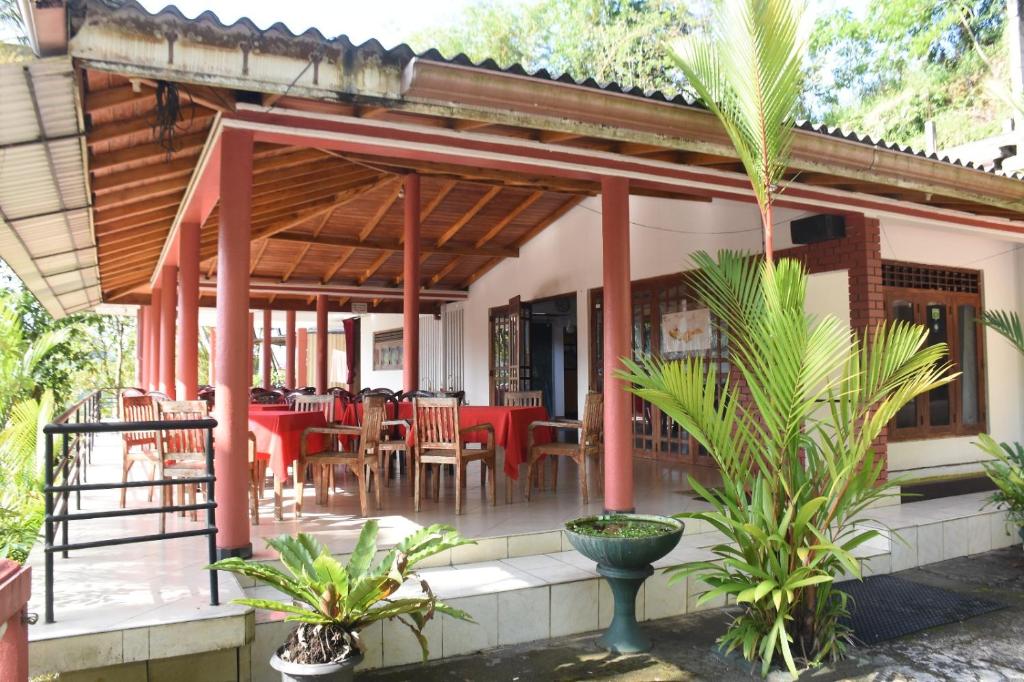 a restaurant with tables and chairs on a patio at Mount Crest Inn Deniyaya in Deniyaya