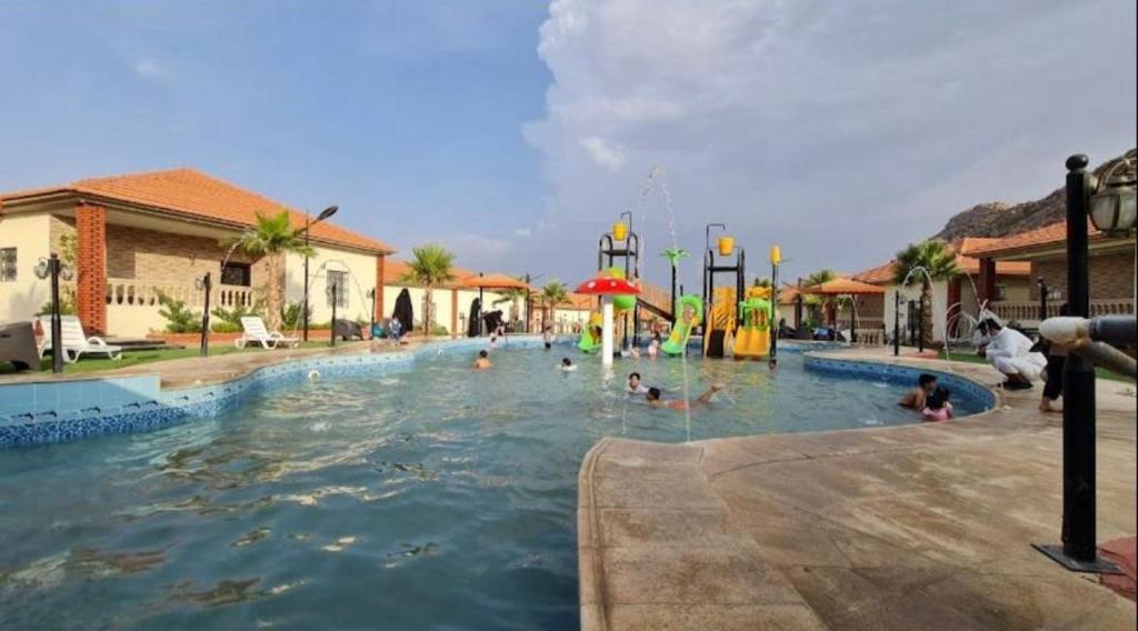 un gruppo di persone in una piscina in un parco acquatico di منتجع الجزيرة الخضراء ad Al Hada