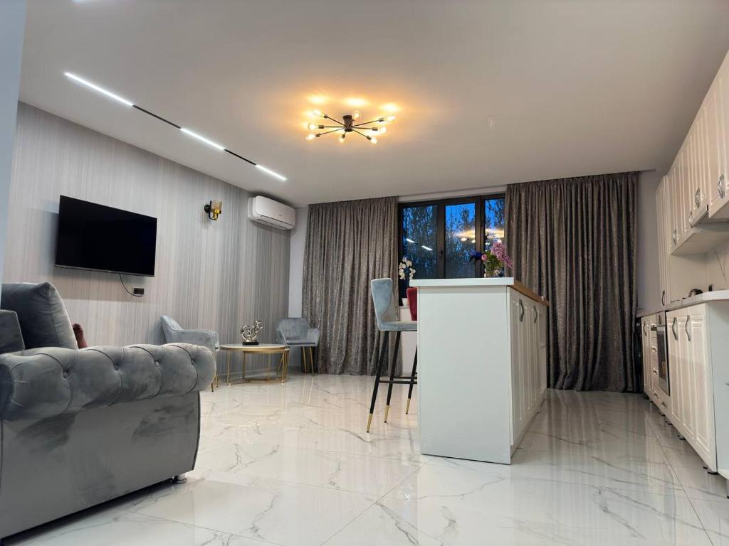 a living room with a couch and a table and a television at Apartment in Erebuni in Yerevan