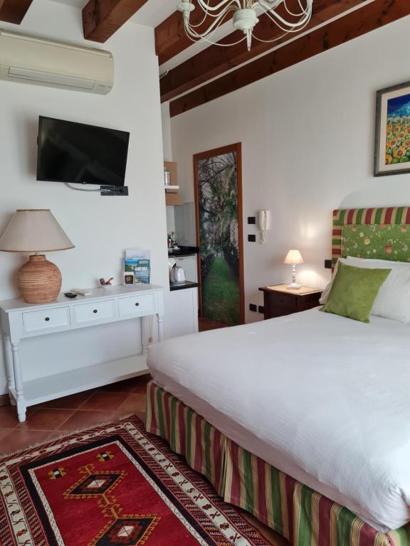 a bedroom with a white bed and a tv at Casa Pianta in Cavallino-Treporti