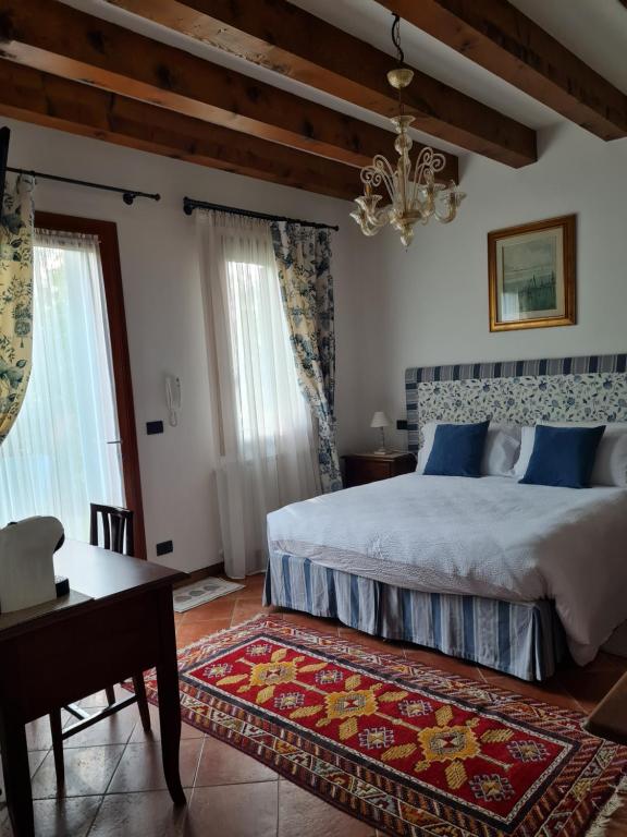 a bedroom with a bed and a table and a chandelier at Casa Pianta in Cavallino-Treporti