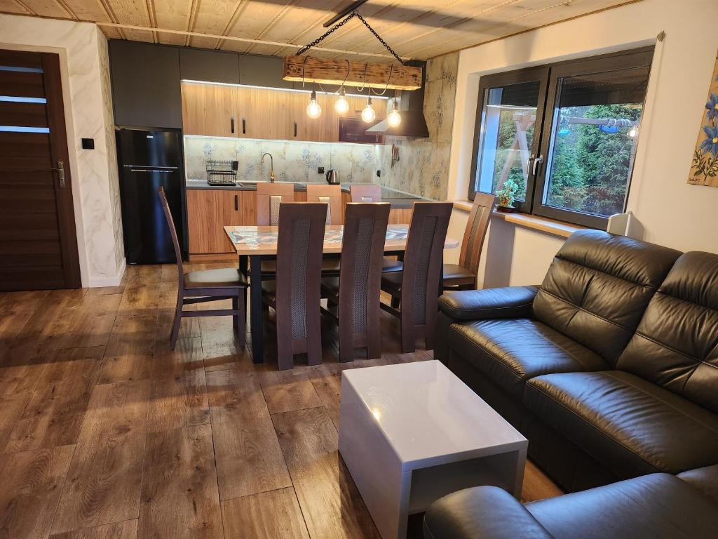 a kitchen and living room with a table and a couch at Domek rodzinny in Piekielnik