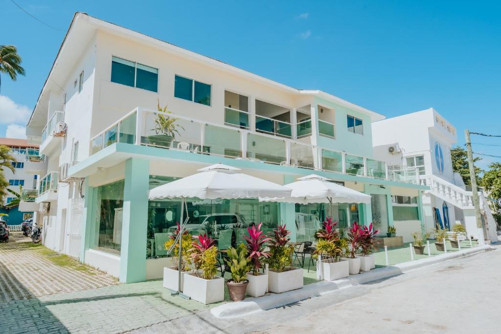 un edificio blanco con sombrillas delante en Green Coast Beach Hotel en Punta Cana