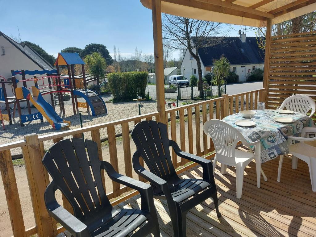 una terraza con mesa y sillas y un parque infantil en CARNAC Mobil-Home Camping 4 étoiles en Carnac