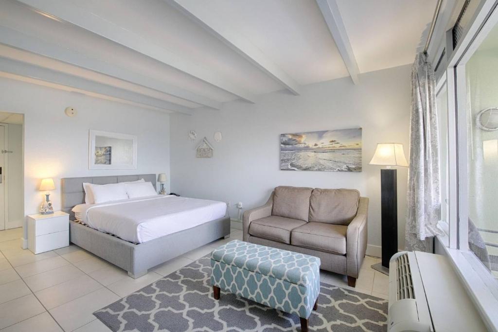 a bedroom with a bed and a couch and a chair at 209 Little Harbor Inn in Ruskin