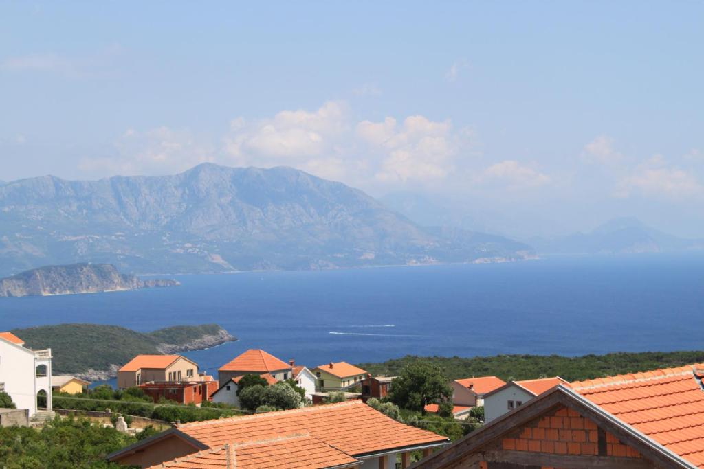 a town with a view of the water and mountains at Apartments Adriatika in Budva
