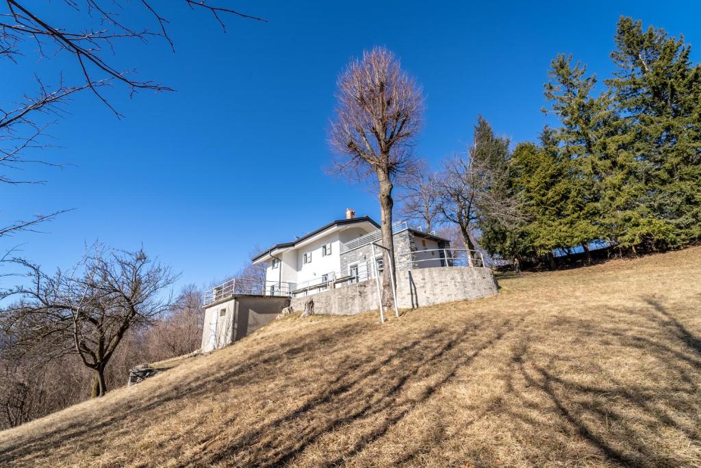 a house on top of a hill with a tree at Chalet la Cà del Fermo in Perledo