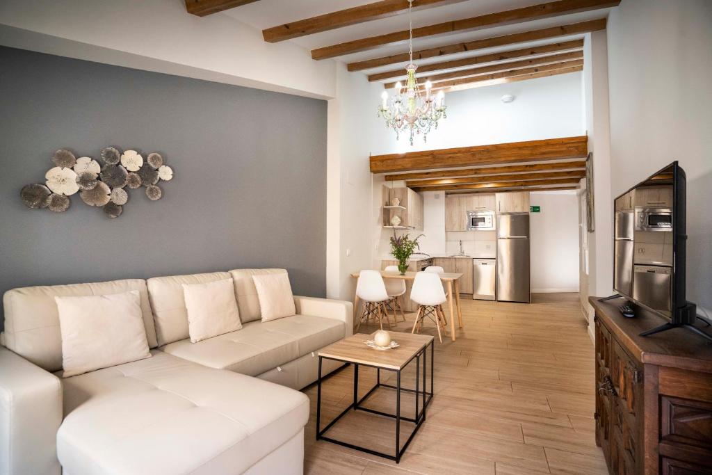 Apartamentos Terraza Ega في إستيلا: غرفة معيشة مع أريكة بيضاء وطاولة