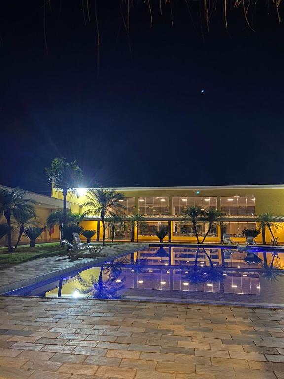 a building with a swimming pool at night at Cerrado Plaza Hotel in Ribas do Rio Pardo