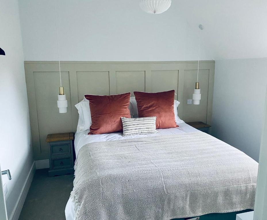 a bedroom with a large bed with two pillows at Luxury Modern Cotswold Cottage in Stow on the Wold