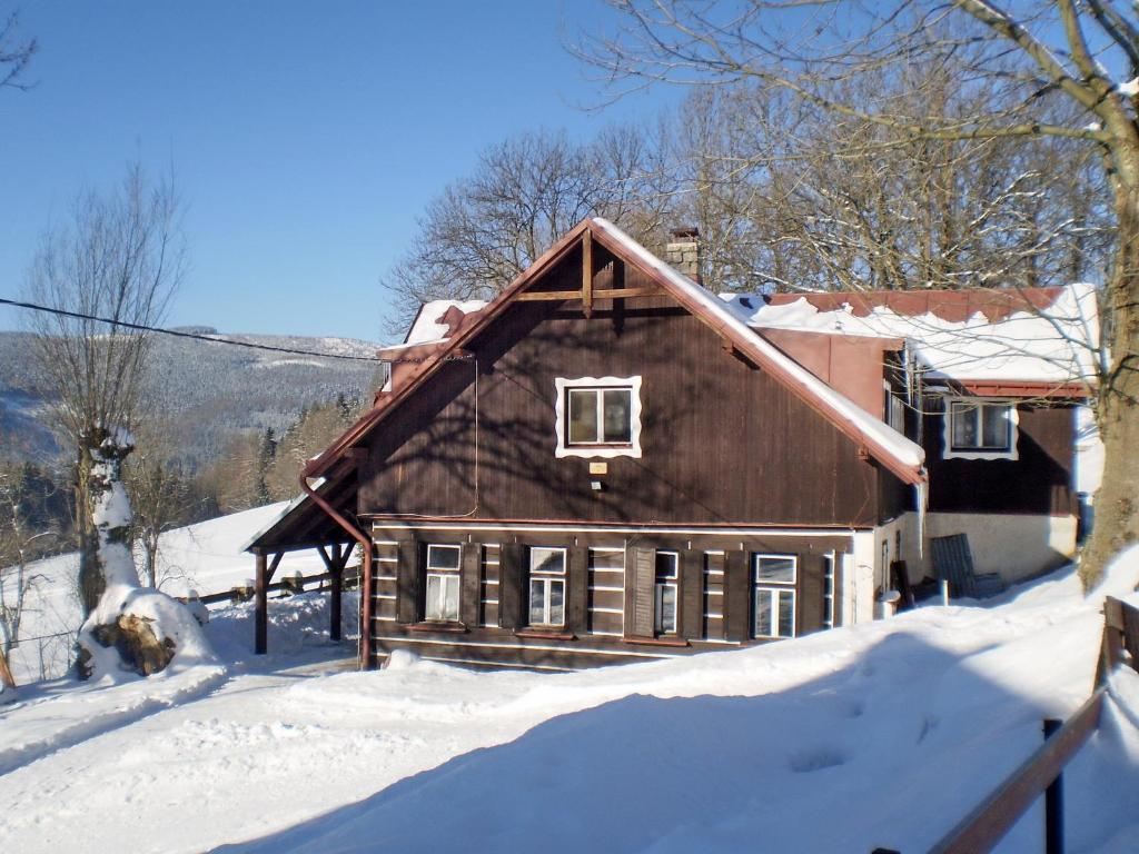 a large wooden house in the snow with snow at Horská chata Roubenka in Strážné