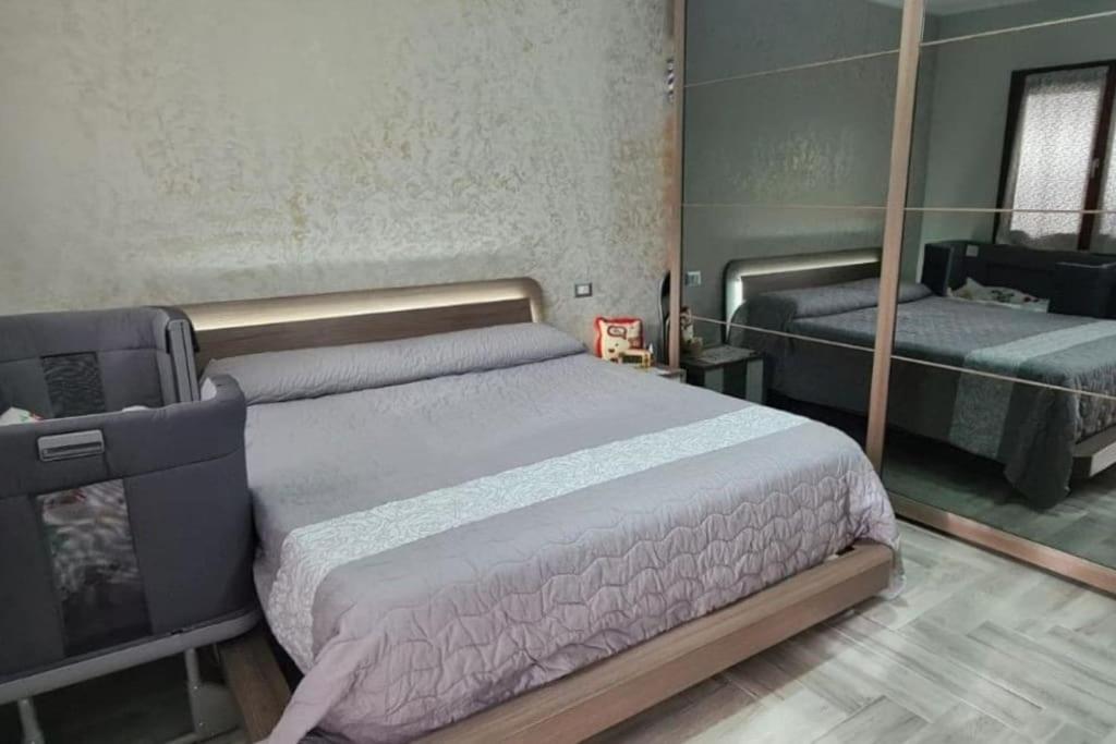 un dormitorio con una cama y un espejo en Casa Laura, Quartu Sant'Elena, en Su Forti