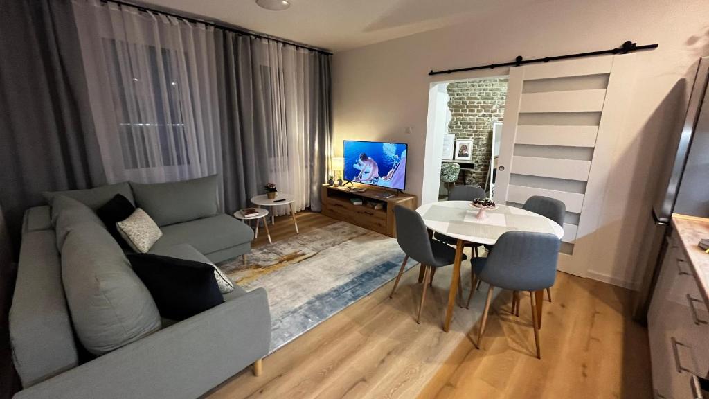Comfortable apartment for 1-4 guests في شورزوف: غرفة معيشة مع أريكة وطاولة مع كراسي