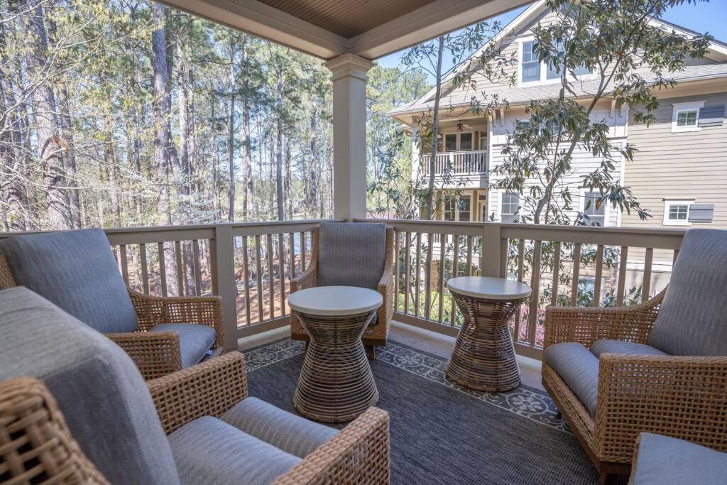 - une terrasse couverte avec des chaises en osier et une table dans l'établissement Stunning Reynolds Lake Oconee, à Greensboro