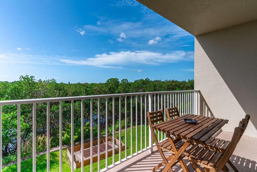 a balcony with two chairs and a wooden table at 3274 Little Harbor in Ruskin
