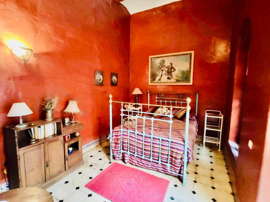 a bedroom with a bed in a red room at La Maison Haute Larache Morocco in Larache