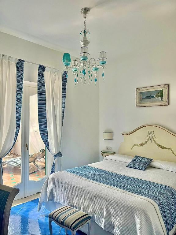 a bedroom with a bed and a chandelier at Hotel Villa Delle Palme in Positano in Positano