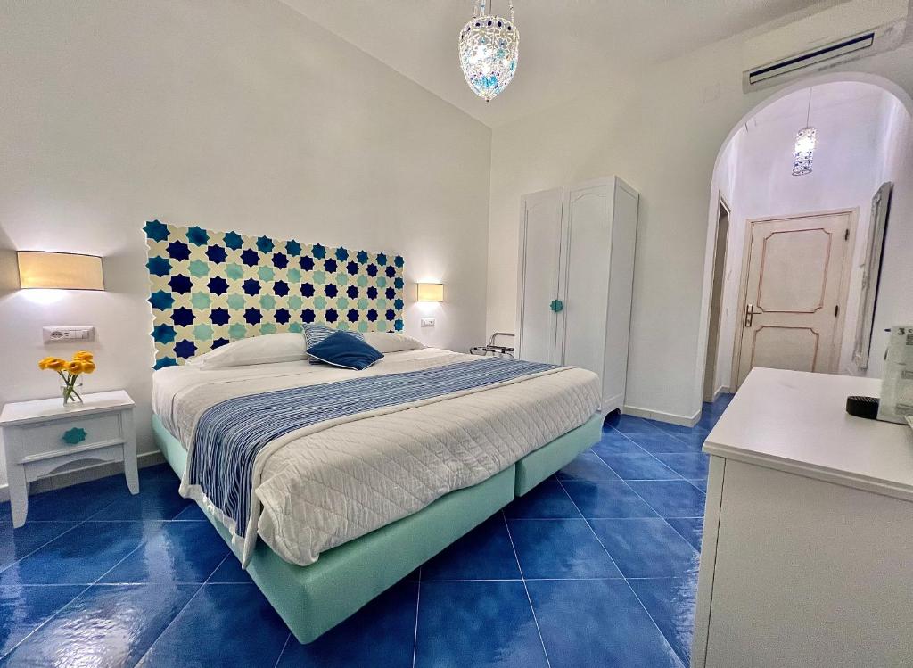a bedroom with a large bed with blue tiles at Hotel Villa Delle Palme in Positano in Positano