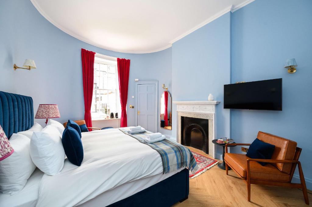 a blue bedroom with a bed and a chair at Cosy City Centre First Floor Family Room in Edinburgh