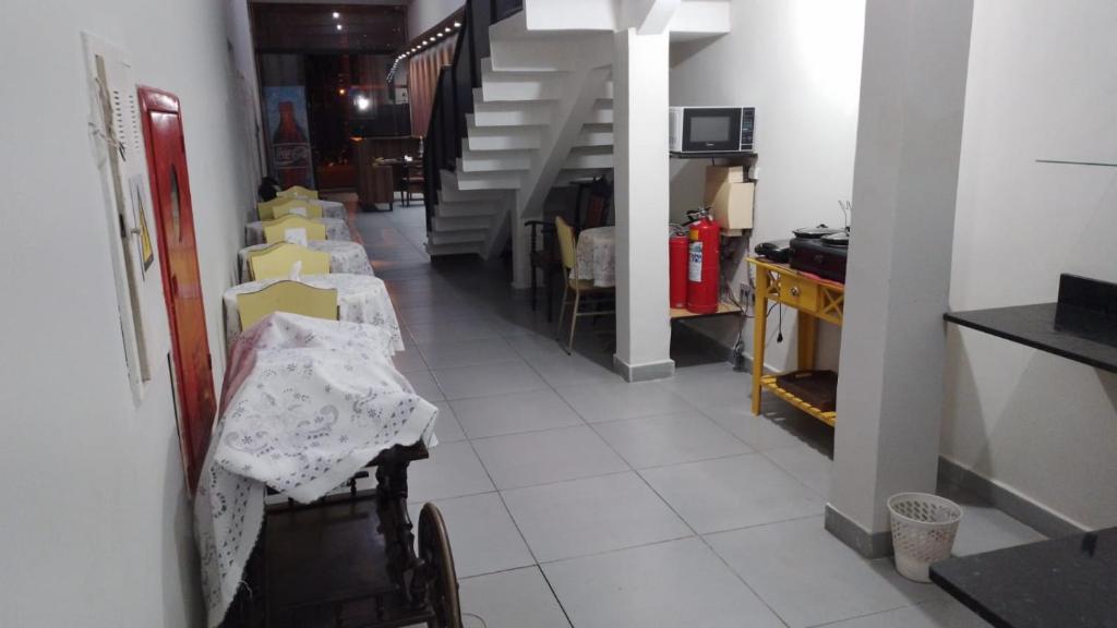 a hallway with a row of tables and stairs at HOTEL ITAVERÁ BRASIL in Presidente Prudente