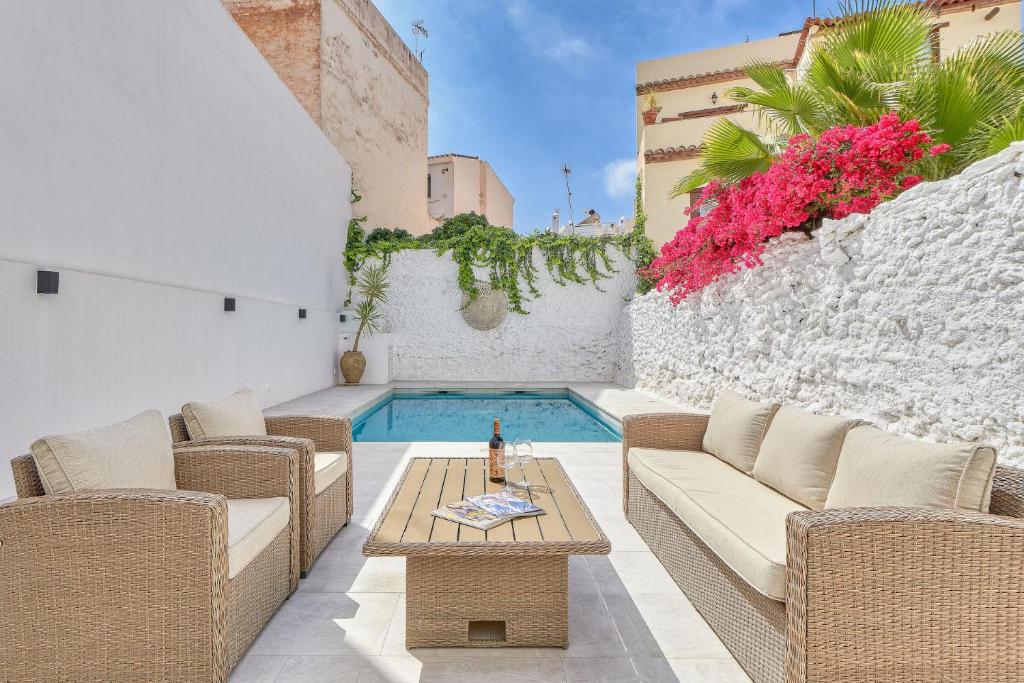 patio z krzesłami i stołem oraz basen w obiekcie Pintada Apartment in Nerja by Solaga Holiday Homes w mieście Nerja