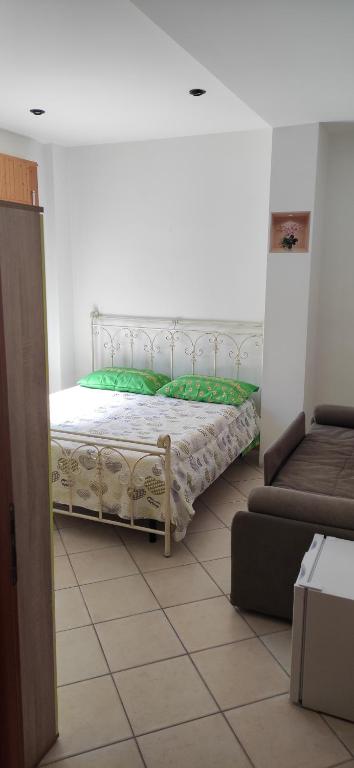 1 dormitorio con 1 cama en una habitación con sofá en Camere da Franco, en Santa Maria del Cedro