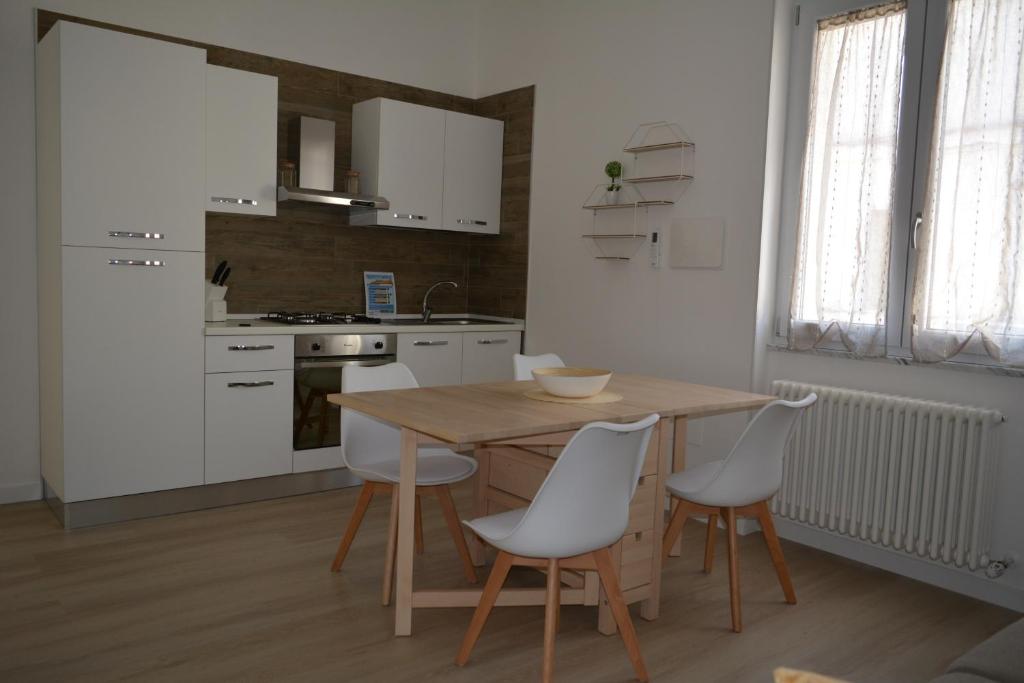 a kitchen with a wooden table and white chairs at Dimora Mucci in Termoli