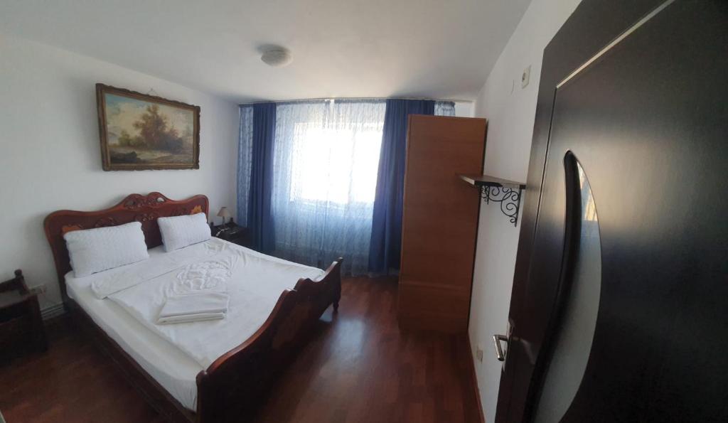 a bedroom with a large bed and a window at Blue Sky Apartament in Constanţa